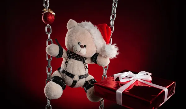 Christmas gift a teddy bear in a Santa Claus hat - an accessory for BDSM games from a sex shop