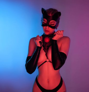 Deri kedi maskeli seksi bir kadın ve seks oyuncakları.