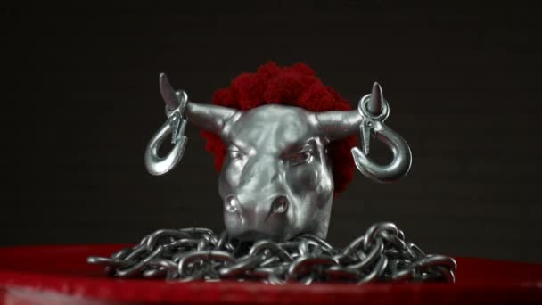 Figurine of a bulls head with transportation hooks on horns and a metal chain — Stock Video