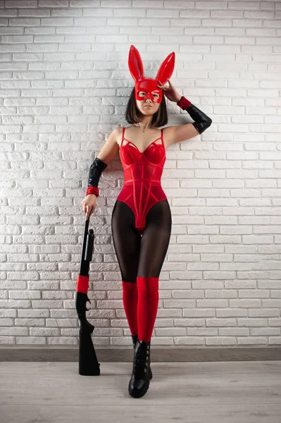 Asiatique fille dans un rouge lapin masque et un sexy rouge body avec un fusil de chasse à l image d un super-héros — Photo