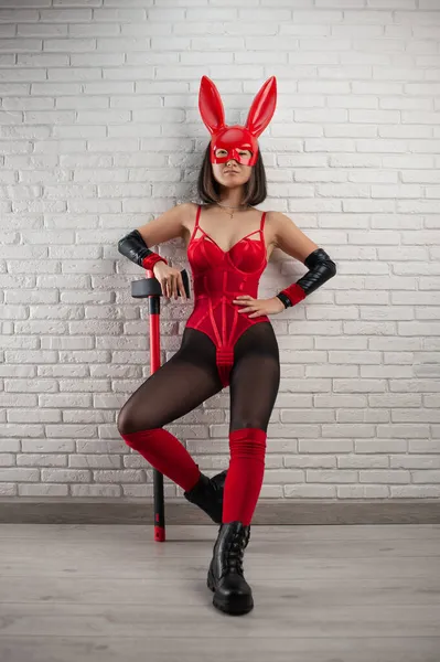Ázsiai lány egy piros nyúl maszk és szexi piros testruha egy fejsze a kép egy szuperhős — Stock Fotó