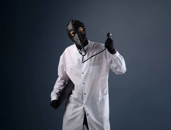 Egy orvos háziköntösben, pestises orvosi maszkban, sztetoszkóppal a kezében. — Stock Fotó
