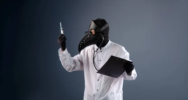 Γιατρός με ρόμπα, με μάσκα γιατρού πανούκλας, εμβολιάζεται. — Φωτογραφία Αρχείου