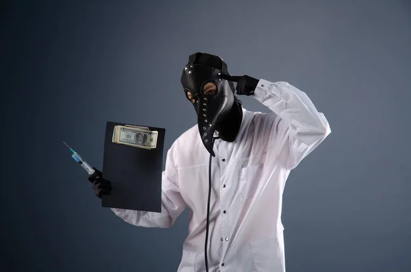 ドレッシングガウンを着た医者が疫病の医者のマスクを着て予防接種をしています — ストック写真
