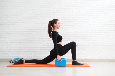 the girl conducts a workout to stretch her body and sit on the splits