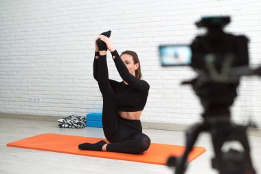 the girl shoots a stretching and twine workout on camera