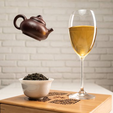 Teçhizatlı çay masası ve çay demlendiği bir şarap bardağı.