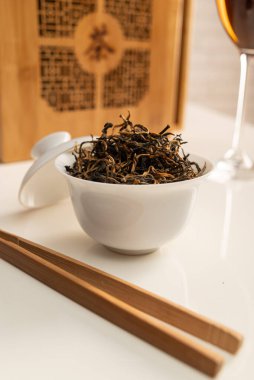 Büyük yapraklı çayın demlendiği, içinde eşyalar ve şarap bardakları olan çay masası.