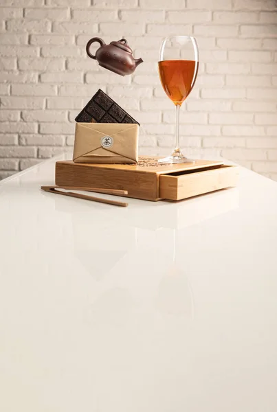 Ein Teetisch mit Tee und ein Weinglas, in das Sheng Puer Tee gegossen wird, um die Farbe zu demonstrieren — Stockfoto