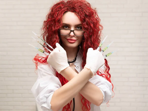 Sexy portrait of a nurse girl with vaccination syringes in her hands — стоковое фото