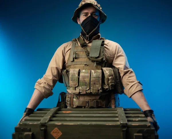 Un soldat en tenue militaire avec une boîte de munitions sur l'épaule — Photo