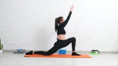 Kız bir ev esneme egzersizi yapıyor. Bölmelerde oturup hamleleri yapıyor.