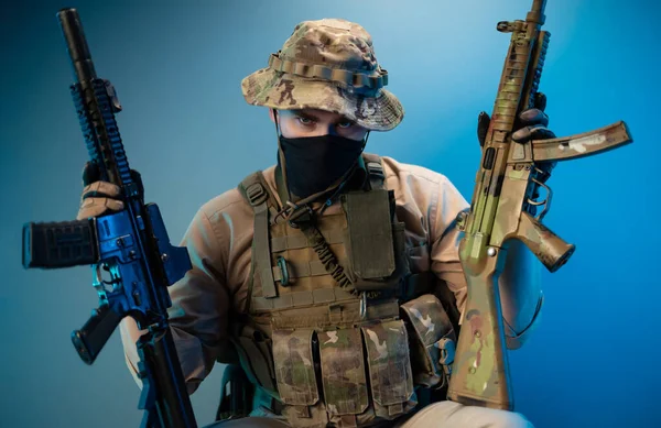 Portré egy gonosz katonáról álcázott katonai ruhában, automata fegyverekkel a kezében. — Stock Fotó