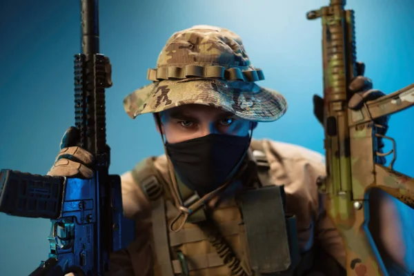 Retrato de um soldado do exército malvado em camuflagem roupas militares com rifles automáticos em suas mãos — Fotografia de Stock