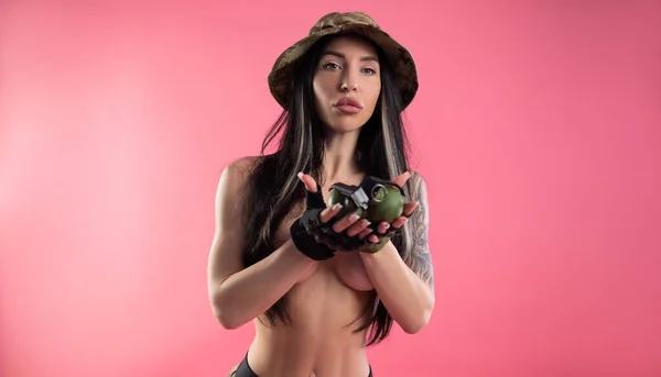 Голая сексуальная девушка в военной одежде держит гранаты на груди — стоковое фото