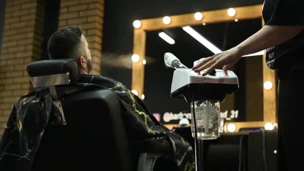 Мужчину в парикмахерской перед бритьем парят на пару с бородой. — стоковое видео
