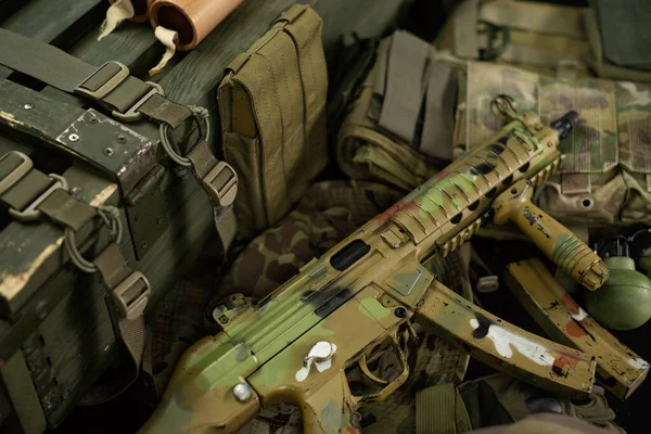Автоматическая винтовка mp5 рядом с ящиком для боеприпасов и другими военными принадлежностями — стоковое фото