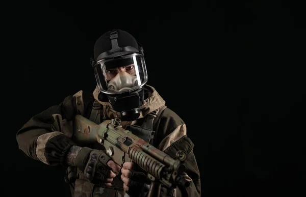 Ein Mann in Militäruniform und Gasmaske hält eine Waffe mit wütendem Gefühlsausdruck — Stockfoto