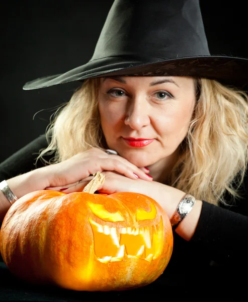 Die charmante Hexe kocht den Trank am Vorabend von Halloween lizenzfreie Stockbilder