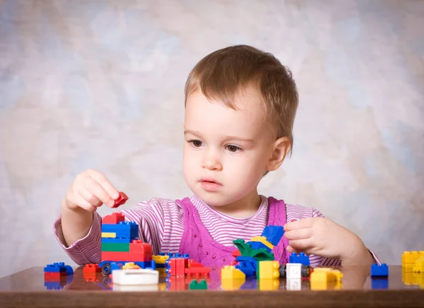The child in a pink dress with toys — Stock Photo, Image