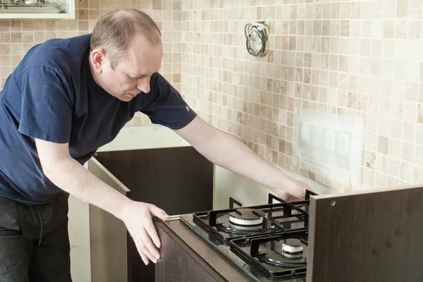 Ambachtsman keuken timmerman op keuken kabinet installatie serv — Stockfoto