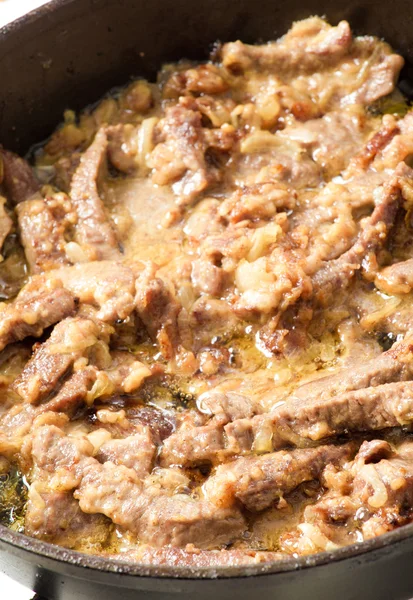 Meat languor on a frying pan with sour cream — Stock Photo, Image