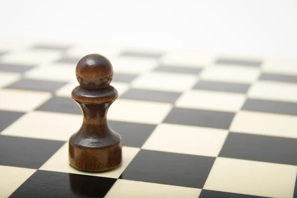 Zwarte pion op een schaakbord — Stockfoto