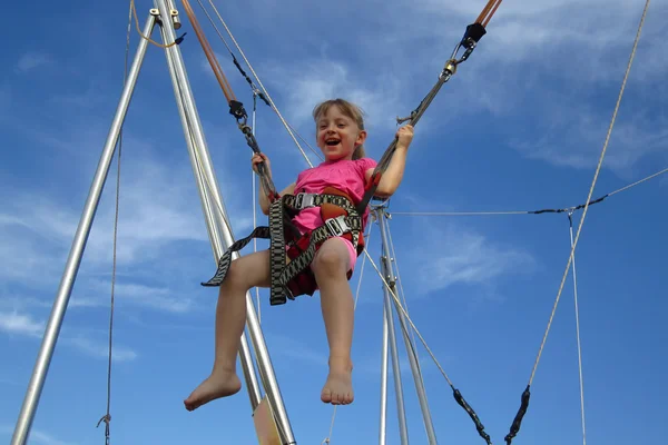 Girl bungee jumping on a trampoline — Stock Photo, Image