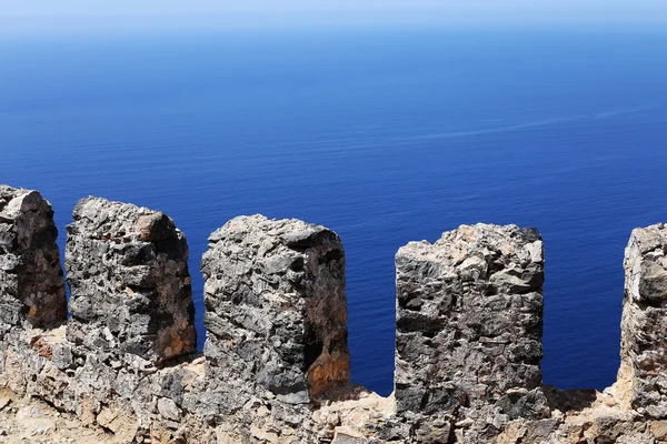 Каменный забор на фоне моря — стоковое фото