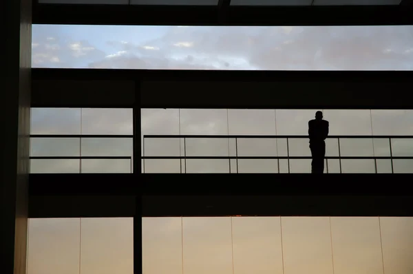 Trabalhador dentro da silhueta do edifício ao pôr do sol — Fotografia de Stock