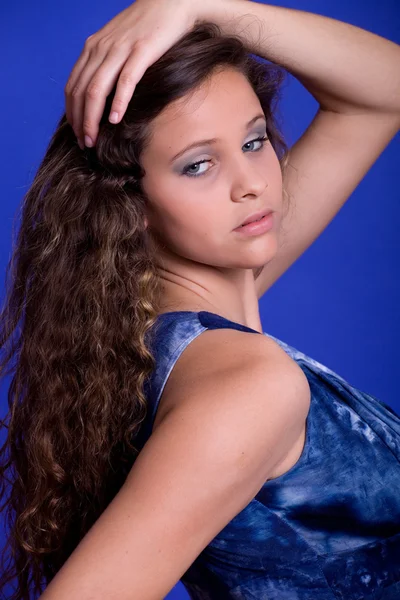 Mladá krásná žena, na modrém pozadí — Stock fotografie