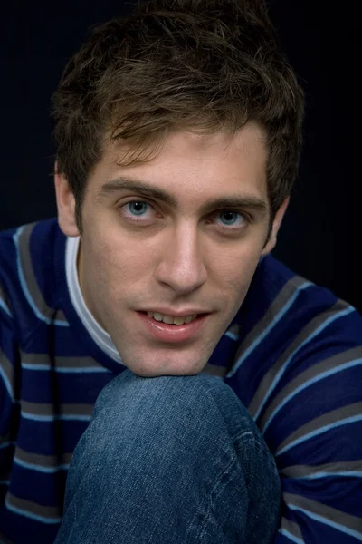 Young casual man against a black background — Stock Photo, Image