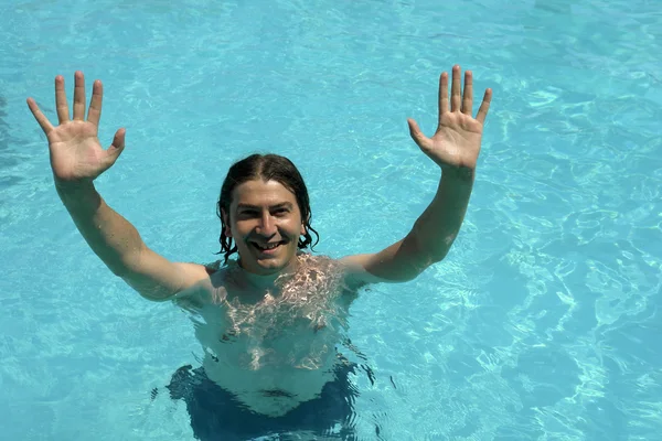 Jeune homme dans une piscine bleue , — Photo