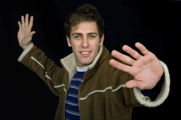 Young casual man against a black background — Stock Photo, Image