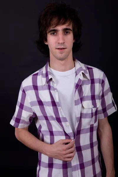 Young casual man against a black background — Stock Photo, Image