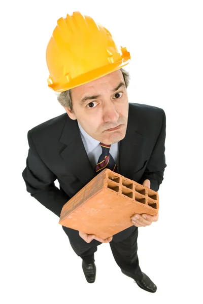 Trabalhador maduro segurando um tijolo — Fotografia de Stock