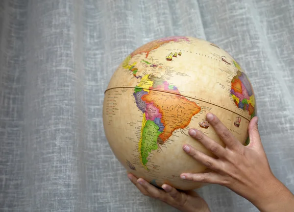 Mujer sosteniendo un mundo globo — Foto de Stock