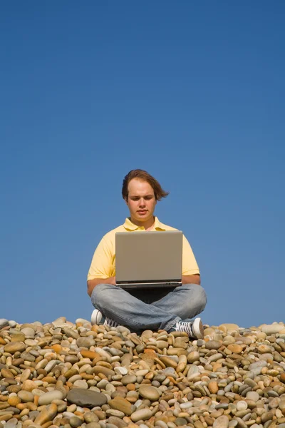 Giovane uomo casual con computer portatile in spiaggia — Foto Stock