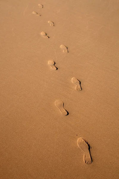 Mänskliga fotavtryck i våt sand i en algarve strand — Stockfoto