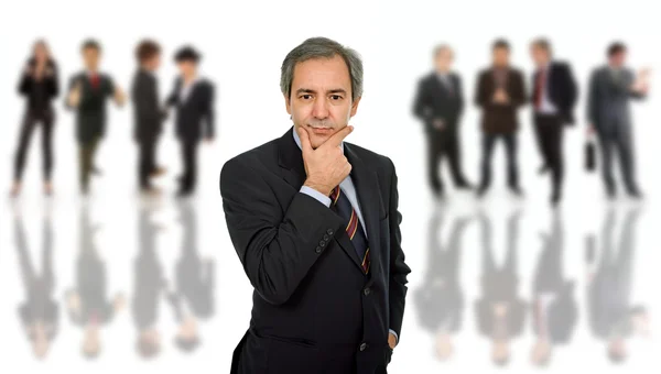 Mature business man portrait with some in the back — Stock Photo, Image