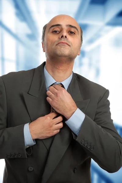 Mature business man adjusting his tie — Stock Photo, Image