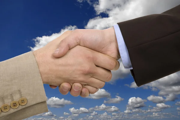 Echipa de afaceri strânge mâna cu cerul ca fundal — Fotografie, imagine de stoc