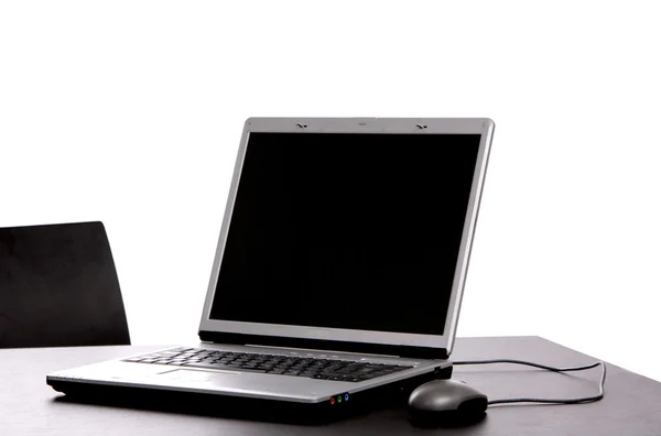 Срібний ноутбук з мишкою на офісному столі — стокове фото