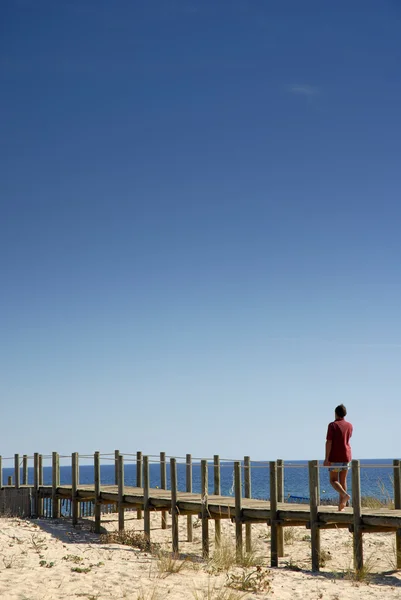 Homem no caminho de madeira na praia — Fotografia de Stock