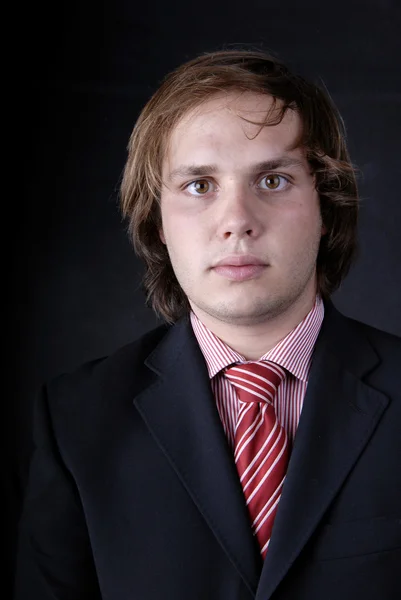 Joven hombre de negocios retrato sobre fondo negro — Foto de Stock