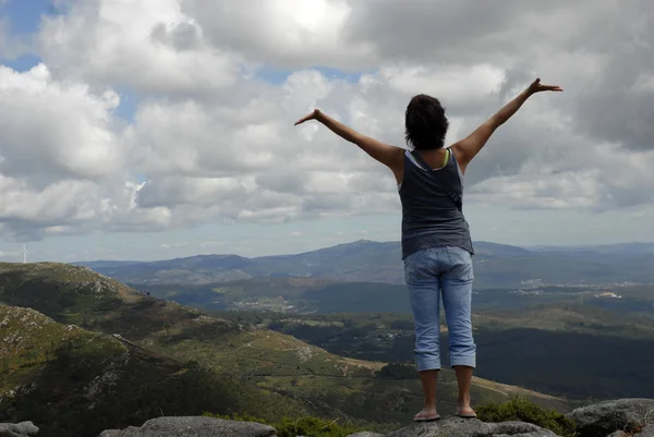 Mujer joven con los brazos abiertos en las montañas —  Fotos de Stock
