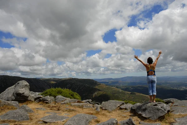 Mujer joven con los brazos abiertos en las montañas — Foto de Stock