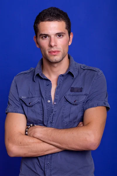 Ένα πορτρέτο του casual νεαρός άνδρας πάνω σε μπλε φόντο — Φωτογραφία Αρχείου