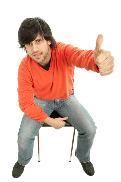 Молодой человек на стуле поднимает большой палец — стоковое фото