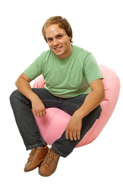 Alkalmi fiatalember ül egy kis kanapé — Stock Fotó